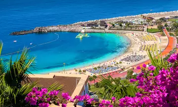 La playa de Amadores está bañada por aguas cristalinas perfectas para darse un chapuzón.