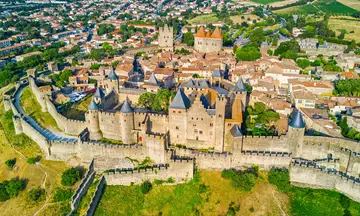 Vista aérea de la ciudadela fortificada de Carcasona, con sus murallas, torres y trazado urbano medieval.