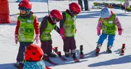 Los niños aprenden a esquiar en el Jardín Alpino de Sierra Nevada, jugando con otros niños de su edad.