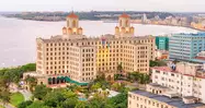 Fachada del Hotel Nacional de Cuba desde sus jardines, con banderas y arquitectura de estilo ecléctico.