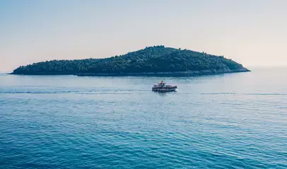 Barco navega con el agua en calma por las aguas del Adriático, Croacia