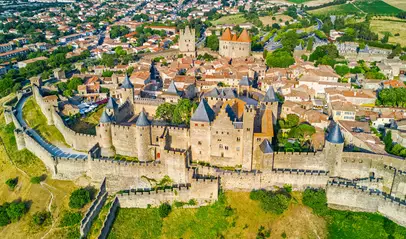 Vista aérea de la ciudadela fortificada de Carcasona, con sus murallas, torres y trazado urbano medieval.